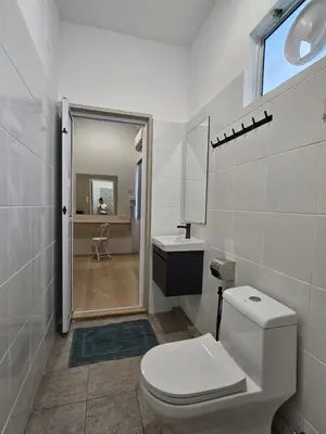 a white bathroom with a toilet and a sink at Summer Home 15 Georgetown Adventist in George Town