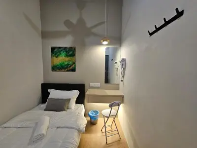 a small bedroom with a bed and a cross on the wall at Summer Home 15 Georgetown Adventist in George Town