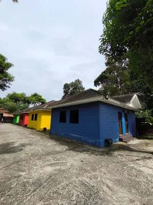 a row of colorful houses sitting on the side of a road at Hotel O Rumah Rehat Awana in Kampong Nanas