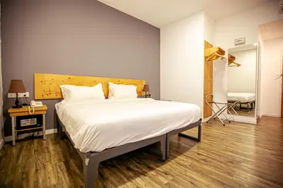 a bedroom with a large bed with a wooden headboard at Chulia Mansion in George Town