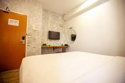 a bedroom with a bed and a tv on a wall at Chulia Mansion in George Town