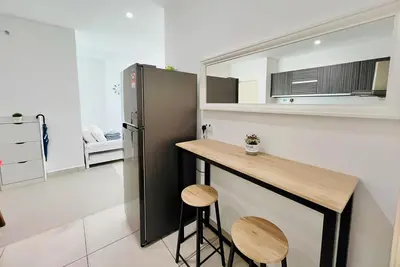 a kitchen with a counter and a refrigerator and stools at Mansion One l 7pax 2R2B l Seaview l Gleneagle l by PerfectSweetHome in George Town