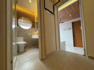 a bathroom with a toilet and a door leading to a shower at Muzi Boutique Hotel in Ipoh