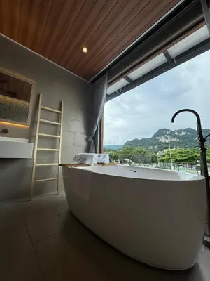 a bath tub in a bathroom with a large window at Muzi Boutique Hotel in Ipoh