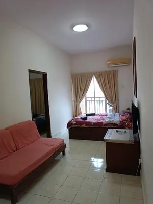 a bedroom with a bed and a couch and a window at Sofea Inn Bukit Merah - Suria A7245 in Simpang Ampat Semanggol