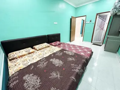 a large bed in a room with blue walls at Shan Homestay in Sungai Petani