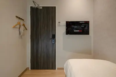 a bedroom with a bed and a wooden door at La Vie Hotel Juru in Simpang Ampat