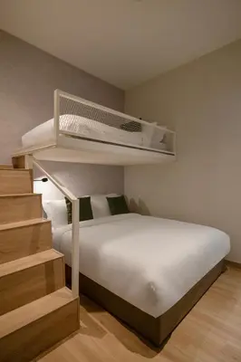 a bedroom with a white bed with a bunk bedweredasteryasteryasteryasteryastery at La Vie Hotel Juru in Simpang Ampat