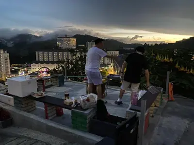 a couple of men standing on top of a roof at Cameron Highlands Blueberry Earth House in Cameron Highlands