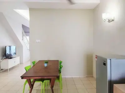 a dining room with a table and green chairs at Tmn seri botani ipoh greece 4br 14pax mahjong in Ipoh