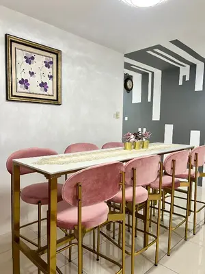 a dining room with a table and pink chairs at MyStay IPOH Manhattan waterpark in Ipoh