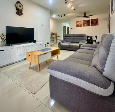 a living room with a couch and a tv at MyStay IPOH Manhattan waterpark in Ipoh