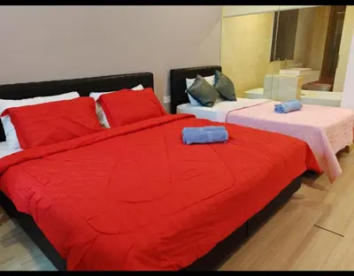 a bedroom with two beds with red blankets and pillows at jazz suite 2 bedroom sea view apartment in Tanjung Bungah