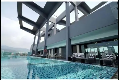 a large building with a swimming pool with chairs at jazz suite 2 bedroom sea view apartment in Tanjung Bungah