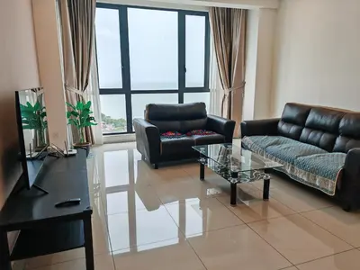 a living room with black leather furniture and a glass table at jazz suite 2 bedroom sea view apartment in Tanjung Bungah