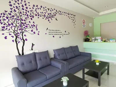 a living room with a tree and purple couches at Star Bay Hotel in Lumut