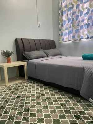 a bedroom with two beds and a table with a couch at Myra Homestay Bertam, Penang in Kepala Batas