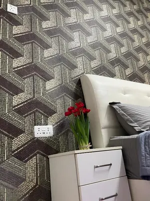 a bedroom with a patterned wall with a bed and a white cabinet at Myra Homestay Bertam, Penang in Kepala Batas