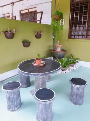 a table and four stools with a plant on it at Syukur Homestay Ipoh in Ipoh