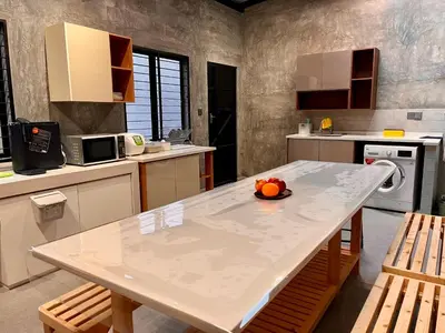 a kitchen with a table with a bowl of fruit on it at Traveler's Stay @ Ipoh (10Pax) in Ipoh