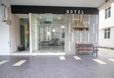 a building with a bench in front of a hotel at JQ Station Eight Inn in Ipoh