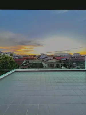 a view of a building with a sunset in the background at HeyFam Homestay in Sekincan