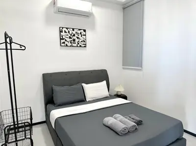 a bedroom with a bed with towels on it at Georgetown Modern Stylish Urban 3BR, InfinityPool with Seaview, 3 Queen bed in Jelutong