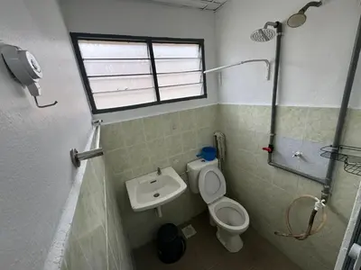 a bathroom with a toilet and a sink and a window at Homestay Cikgu Iqa (Muslim) in Kuala Kangsar