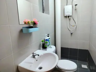 a bathroom with a sink and a toilet and a mirror at Emerald Avenue Brinchang 8 guests 3 bedrooms in Brinchang
