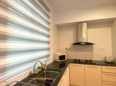 a kitchen with a sink and a microwave at Shamrock Breeze Villa: Coastal Haven for 29 Guests in Batu Ferringhi