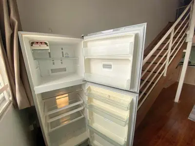 a refrigerator with its door open next to a staircase at Minimalist Duplex @ BayanLepas in Bayan Lepas