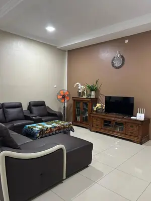 a living room with a couch and a flat screen tv at Homestay De' Afraa Sungai Besar IslamFriendly in Sungai Besar