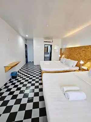 two beds in a room with a checkered floor at The 60 in George Town