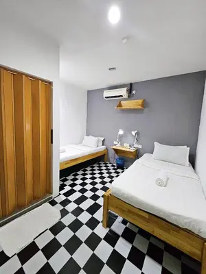 a bedroom with a bed and a black and white checkered floor at The 60 in George Town