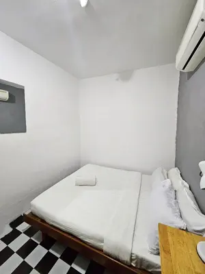 a white bed in a room with a checkered floor at The 60 in George Town