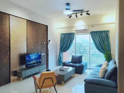 a living room with a blue couch and a tv at INS Pavillion by irainbow in Ipoh