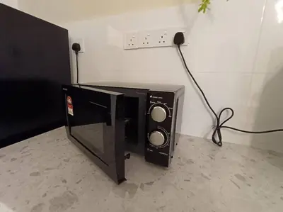 a microwave sitting on the floor next to a wall at The Horizon Ipoh Dual L13 by Grab A Stay in Ipoh