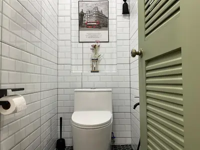 a bathroom with a toilet and a picture on the wall at Jessie Home in Bukit Mertajam