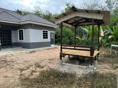 a wooden bench in front of a house at D’Asam Homestay Baling in Baling