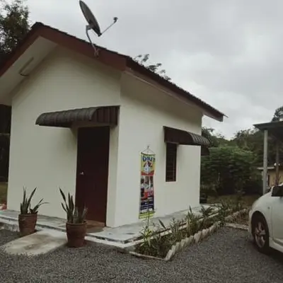 a small white house with a car parked in front of it at Chalet Naqib in Gerik