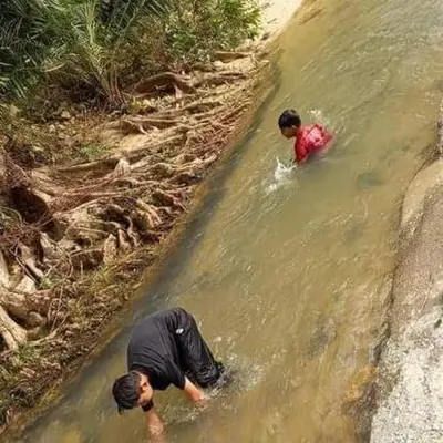 two people in the water in a river at Chalet Naqib in Gerik