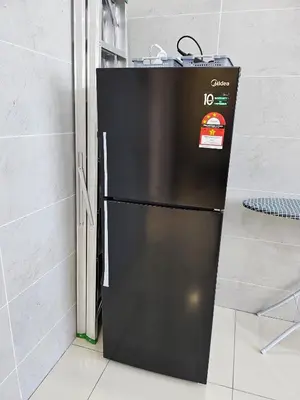 a black refrigerator sitting next to a wall at Air-home No 28 Simpang near Aulong Econsave, 3BR, 7pax, Netflix in Simpang