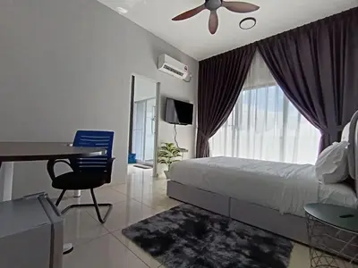 a bedroom with a bed and a table and a ceiling fan at The Horizon Ipoh Dual L12 by Grab A Stay in Ipoh