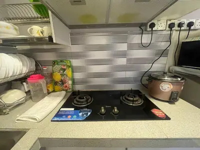 a small kitchen with a stove top in a caravan at ROYAL LILY TANAH RATA BY JUNIKASTAY in Tanah Rata