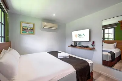 a hotel room with a bed and a mirror at GAIA Hotel in Tanjung Bungah