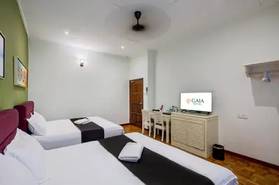 a hotel room with two beds and a desk at GAIA Hotel in Tanjung Bungah