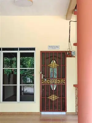 a red door with a sign on it in front of a building at KhaAfi Homestay Seri Iskandar in Kampung Bota Kiri