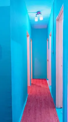 a hallway with blue and pink doors and a red carpet at COZY, FAMILYSTAY, BAYAN LEPAS, only 4pax, 1car parking in Bayan Lepas