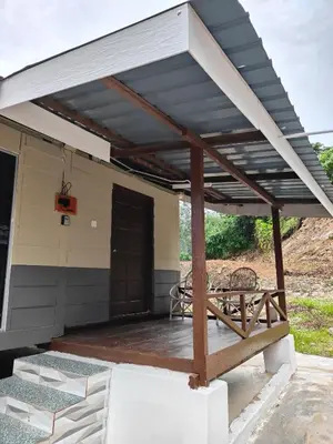 awning over a porch of a house with a picnic table at Homestay Teratak D`kemangi with Private Pool in Baling