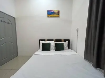a bedroom with a white bed with two green pillows at Ipoh Family Cozy Homestay 4R4B 12-13pax SY23 in Ipoh